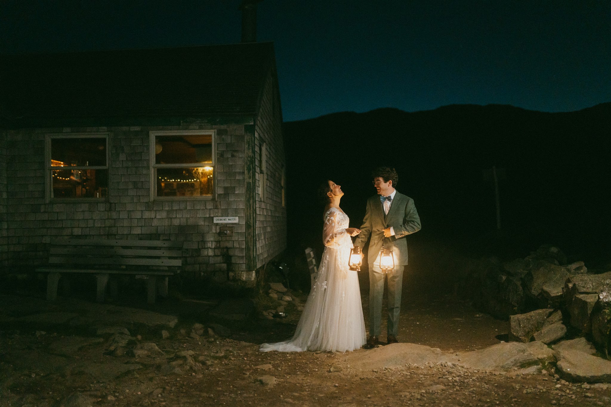 A couple share their first look by lantern light, in the pre-dawn hours outside of the AMC Lakes of the Clouds hut in the White Mountains of New Hampshire. 