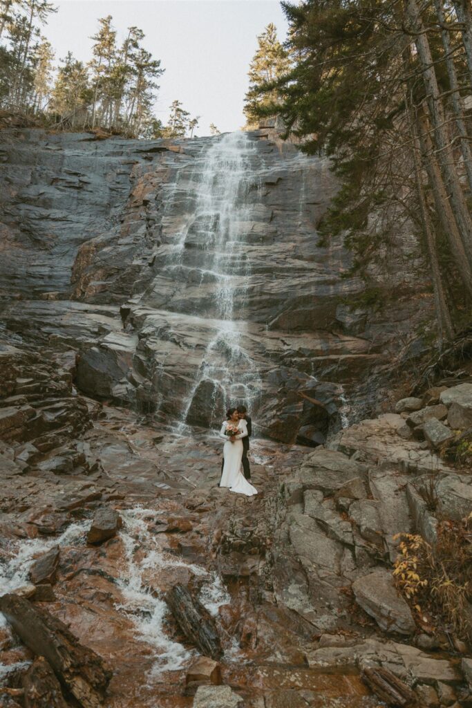 Couple standing at the base of Arethusa Falls in Crawford Notch State Park
