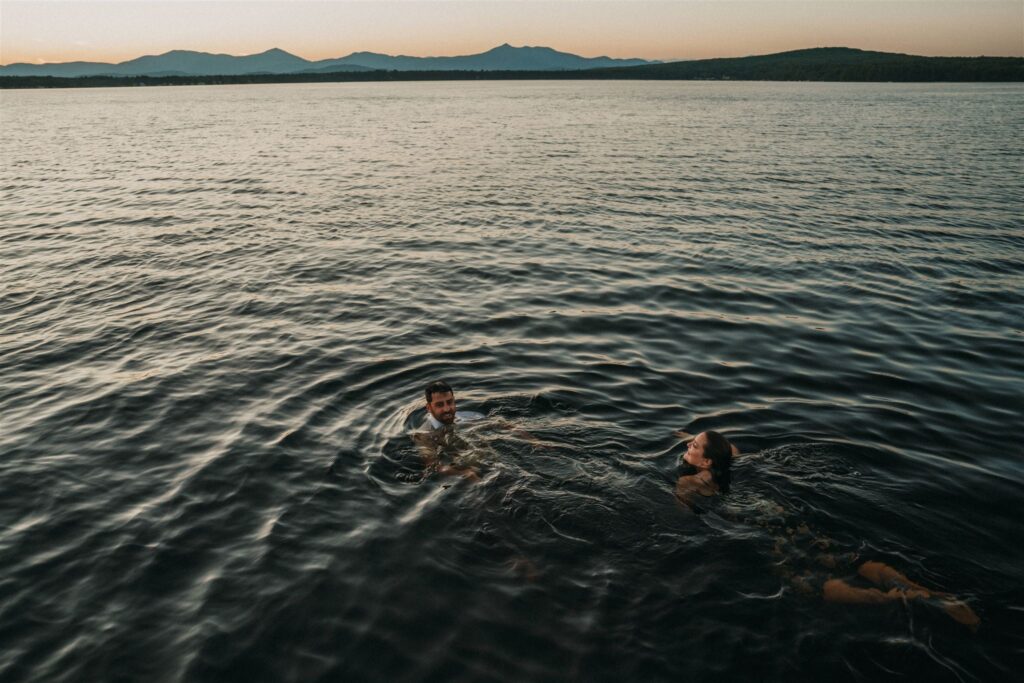 Couple swimming in the lake at sunset.