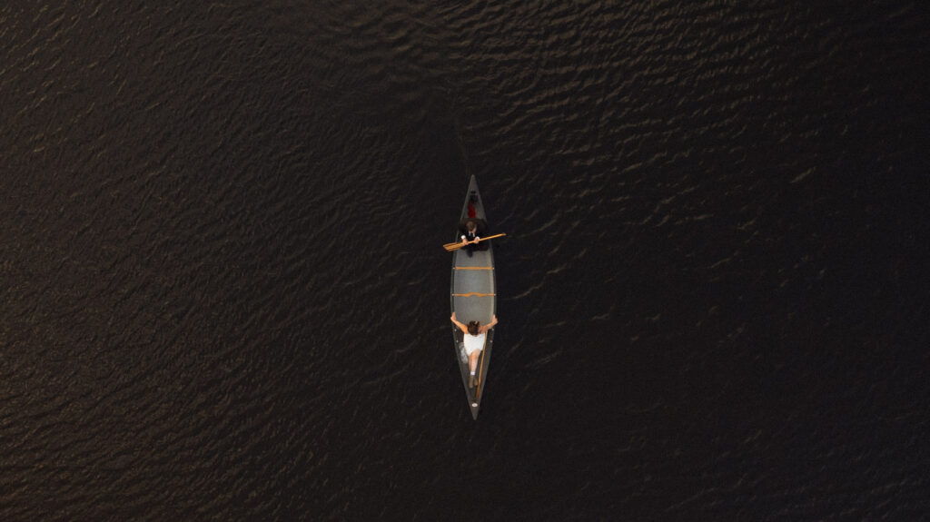 Aerial view of a couple canoeing on a lake during their White Mountains elopement