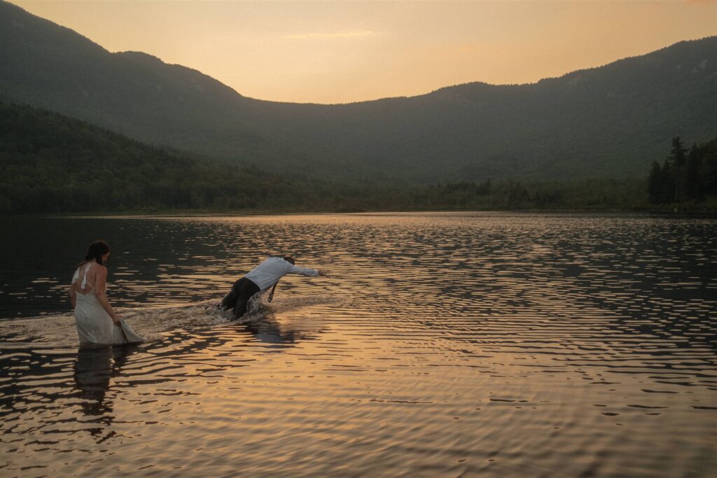 Couple laughing and moving through the water during a relaxed elopement day at sunset