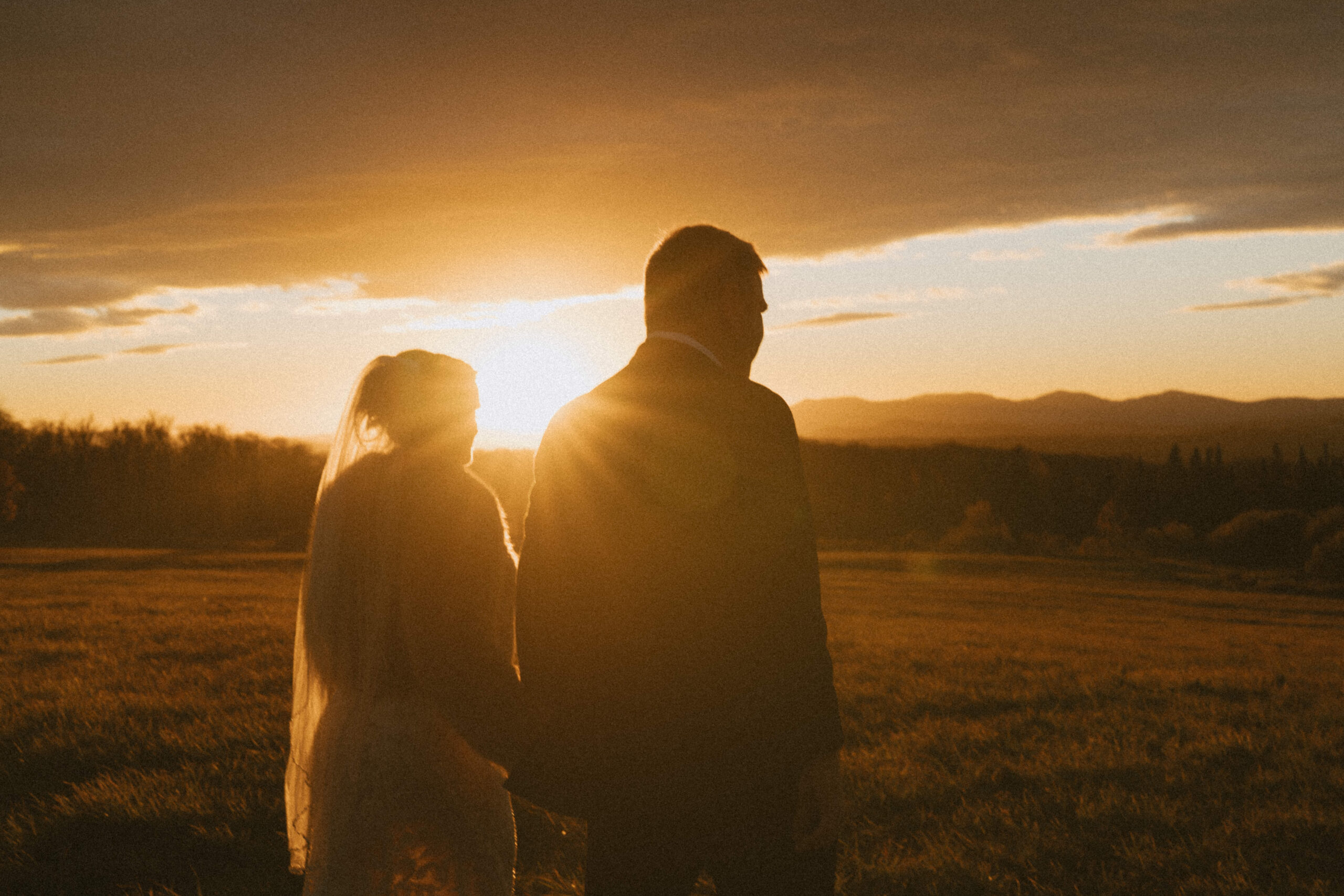 Couple walking together at sunset in the mountains, seen from behind