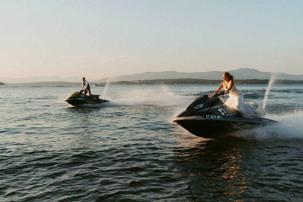 Couple riding jet skis across a lake during a multi day White Mountains elopement adventure