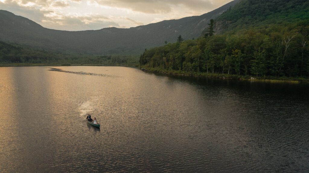 Couple canoeing on a lake in the White Mountains of New Hampshire during an elopement