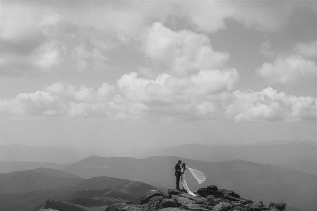 Couple standing together on a mountain summit during a White Mountains elopement