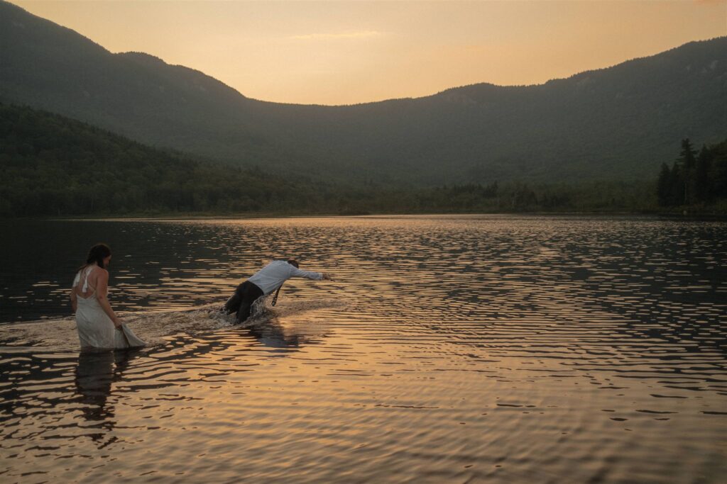 Couple playing in the water during a summer elopement in the White Mountains