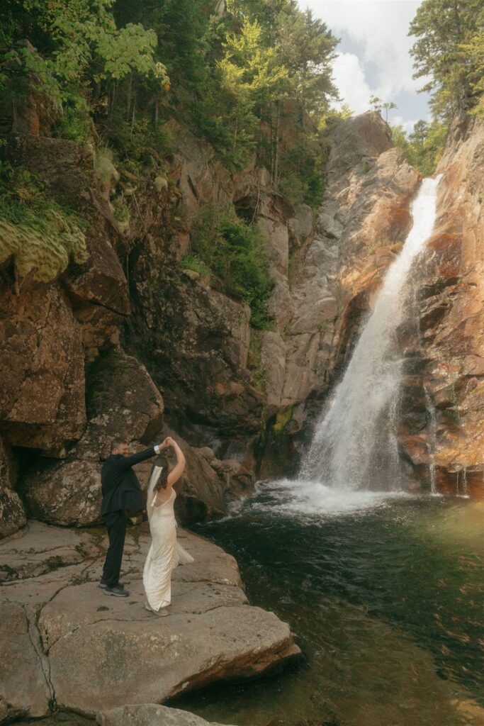 Couple dancing beside a waterfall during their White Mountains elopement adventure